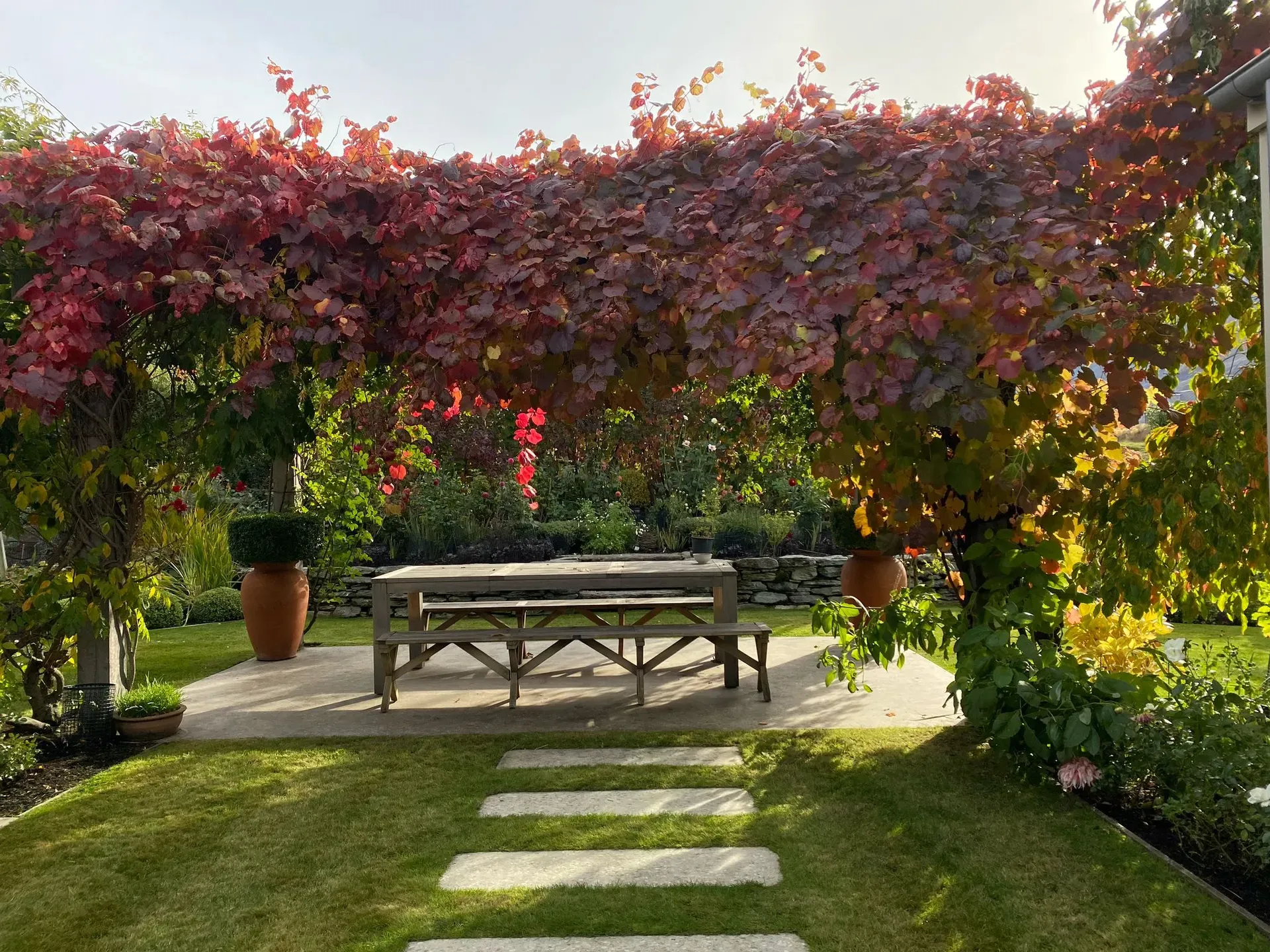 Perfectly manicured luxury garden with stone pathways and evergreen hedges